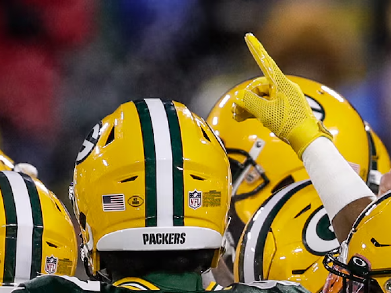 Green Bay Packers shown in a huddle.