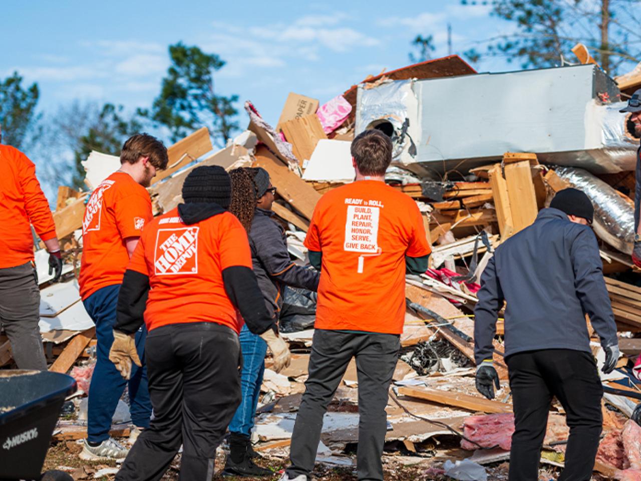 Destruction by a tornado shown. Members of Team Depot shown at the disaster site.