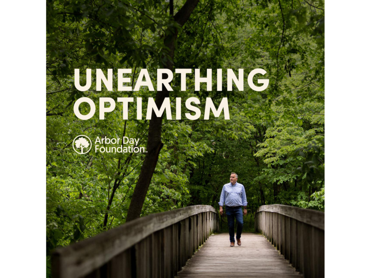 Unearthing Optimism Podcast art, featuring man walking down a bridge in a forest. 