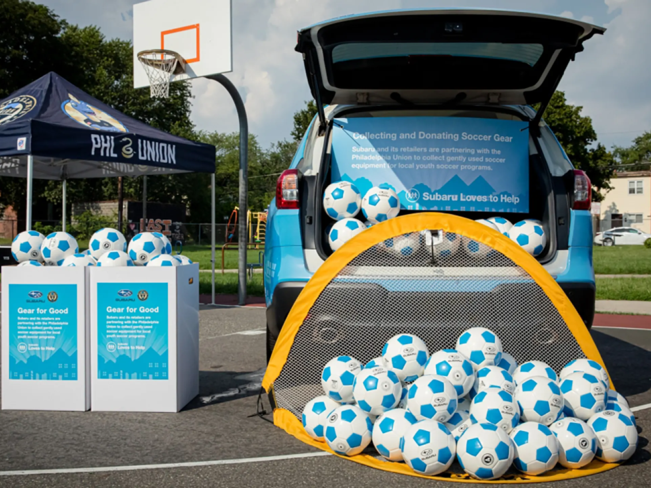Lots of soccer balls displayed outside a Subaru Loves to Help Event