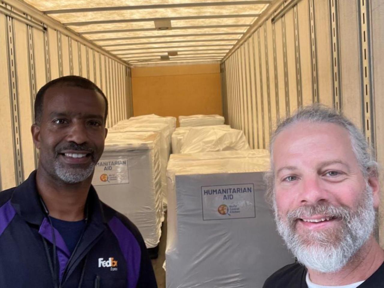 two people smiling with packages in background