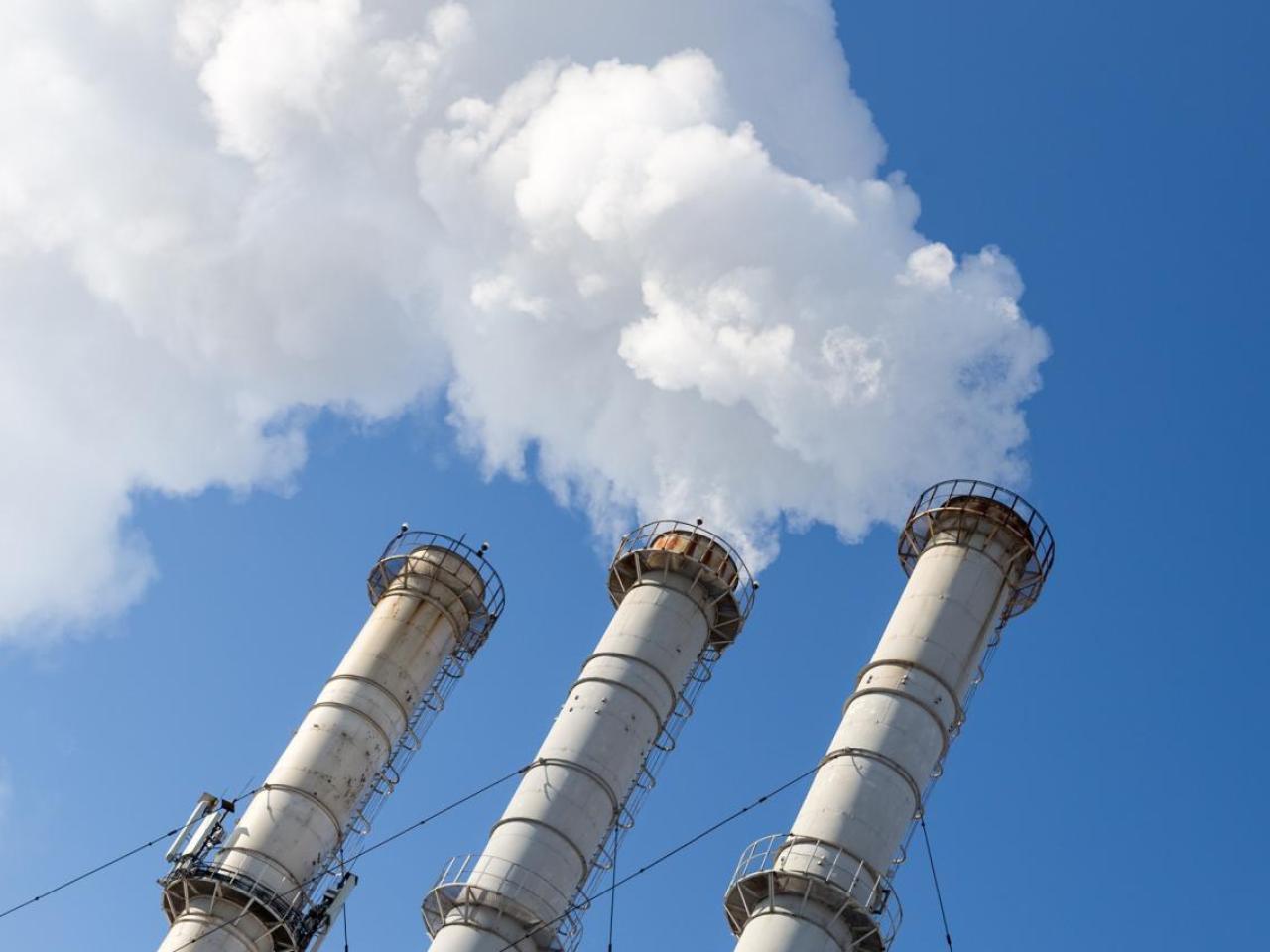 Smoking pipes making clouds against blue sky background