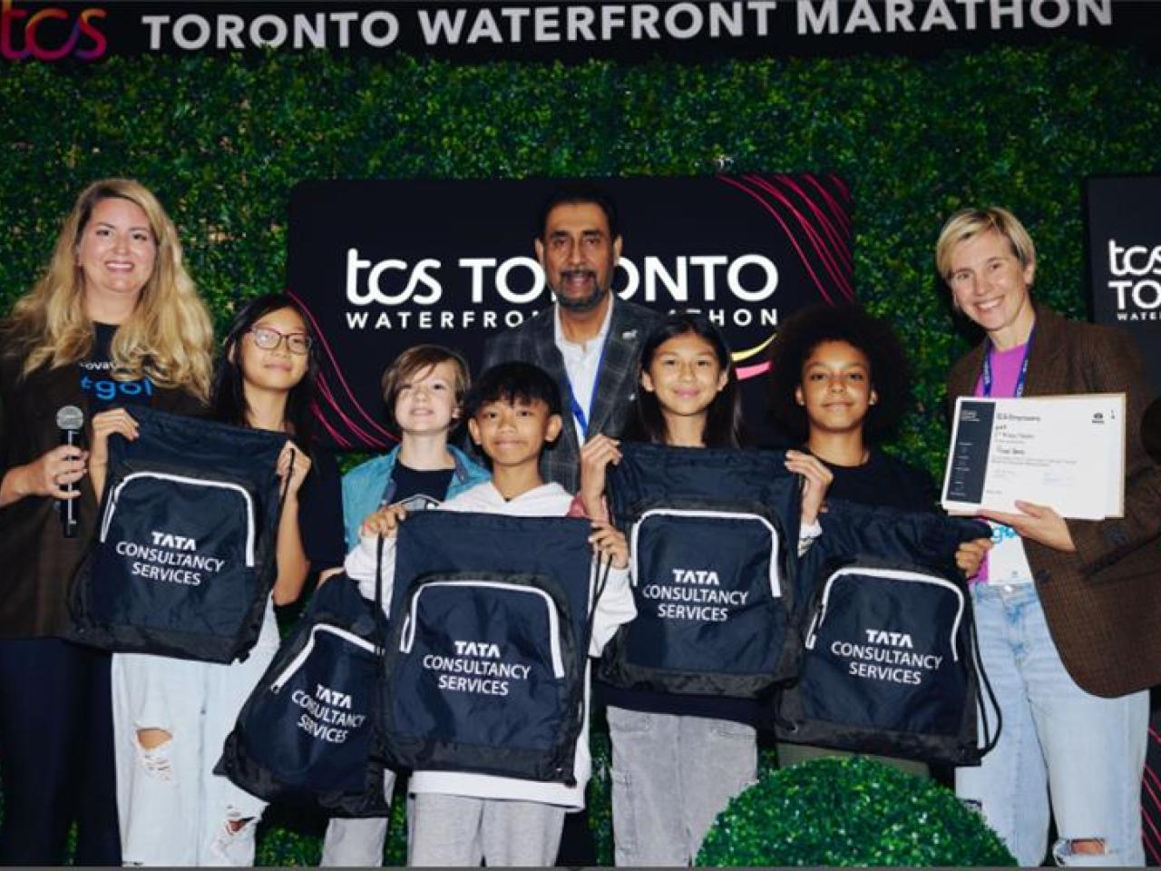 Students holding drawstring Tata Consultancy Services bags