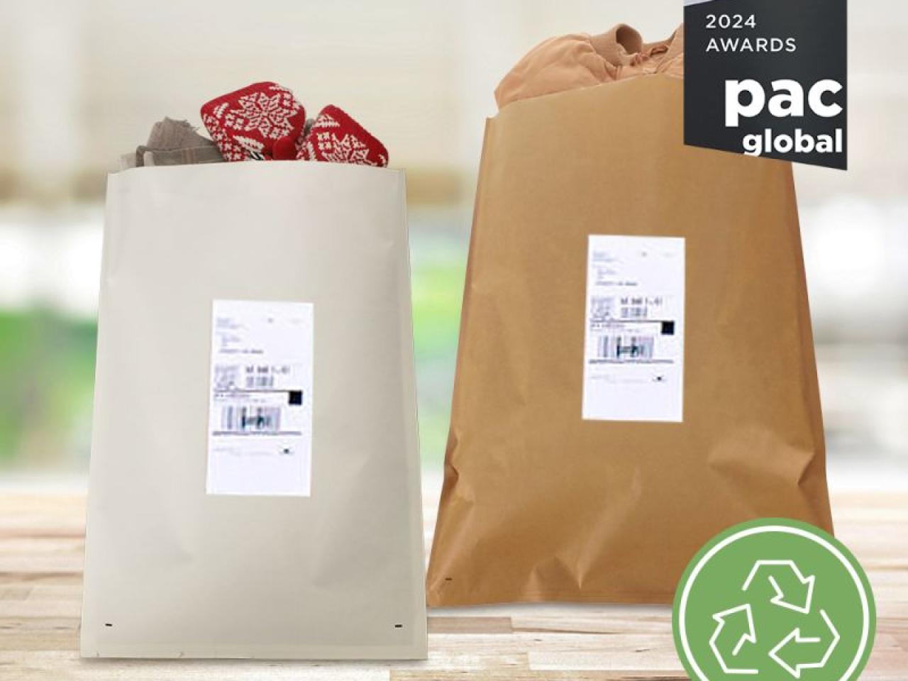Two shipping bags with items inside on a flat wooden surface. SEE and Autobag logos. "Best in Class 2024 Awards pac Global" badge and recycling symbol in the corner.