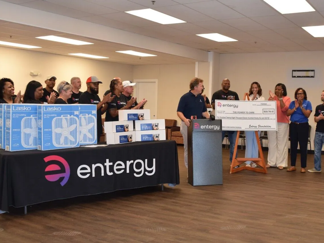 An oversized check being presented, a group clapping