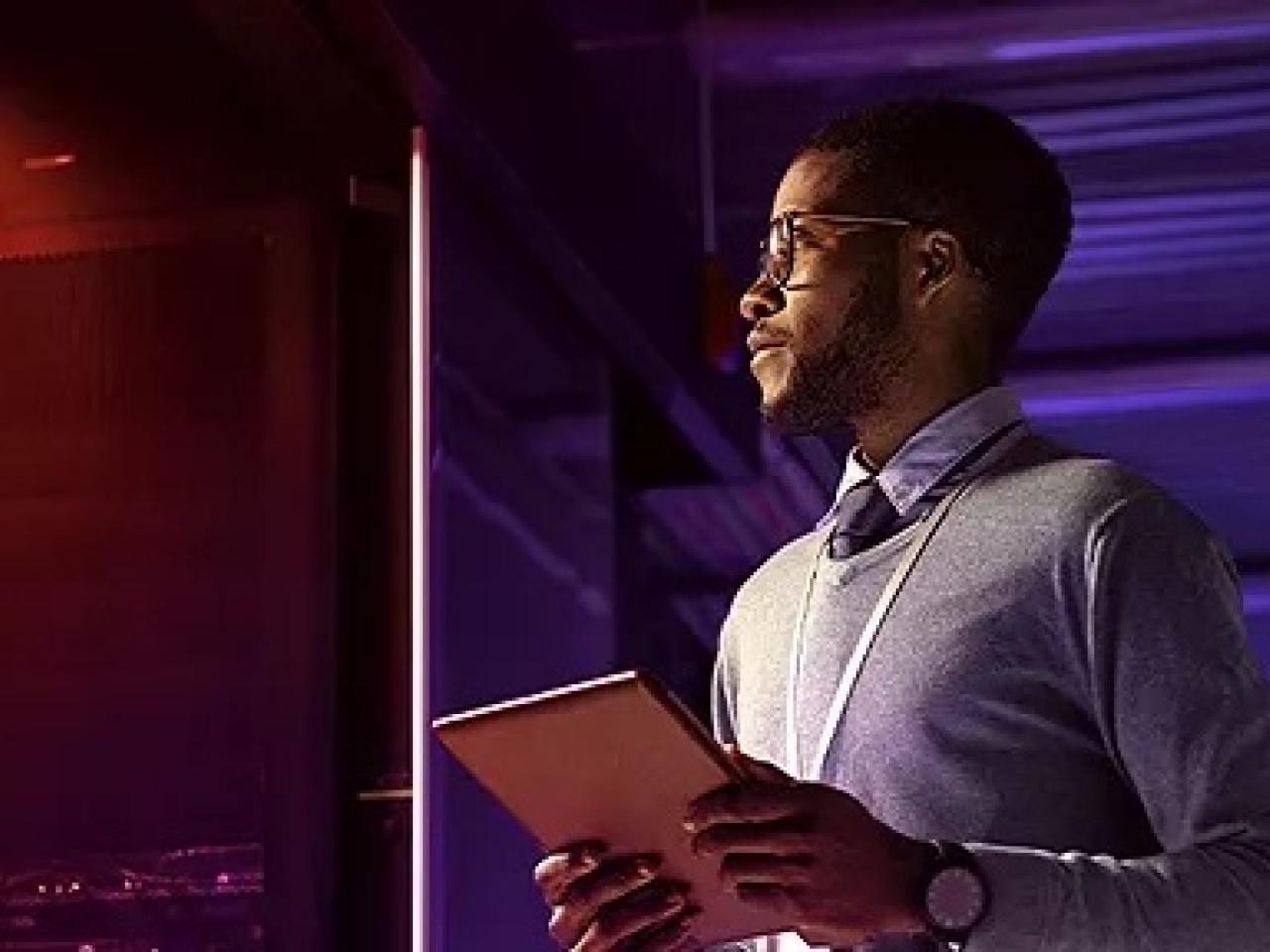 person holding a tablet in a dark room