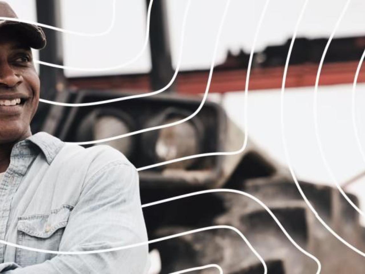 A person outside in front of a tractor.