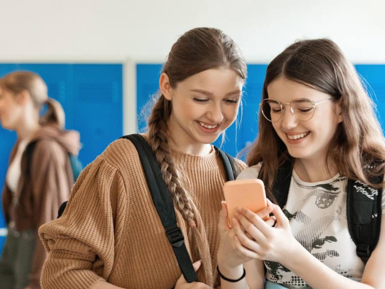 Two teenage girls looking at a phone together 