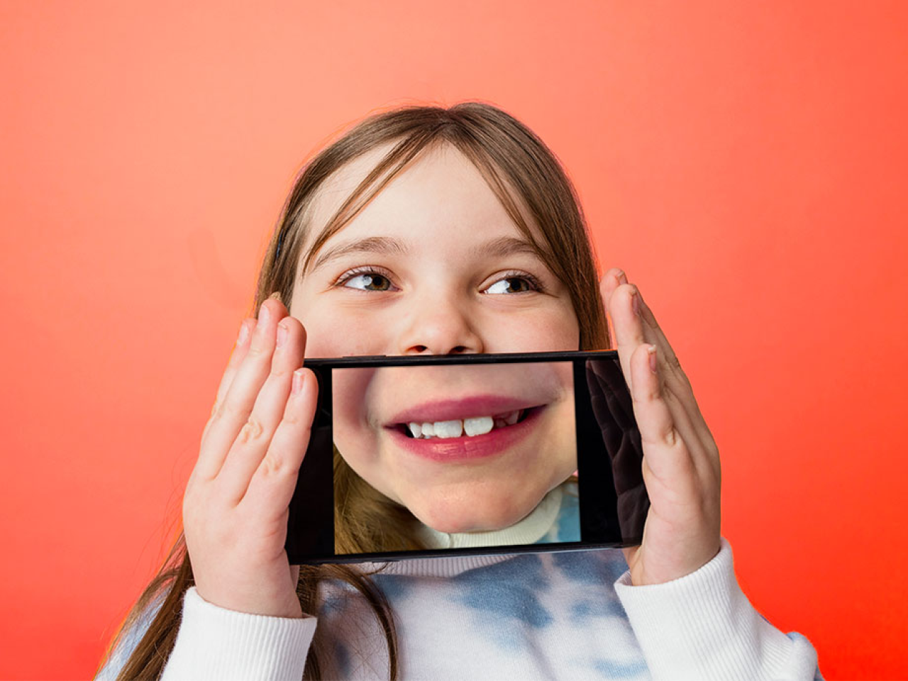 Child holding up cellphone