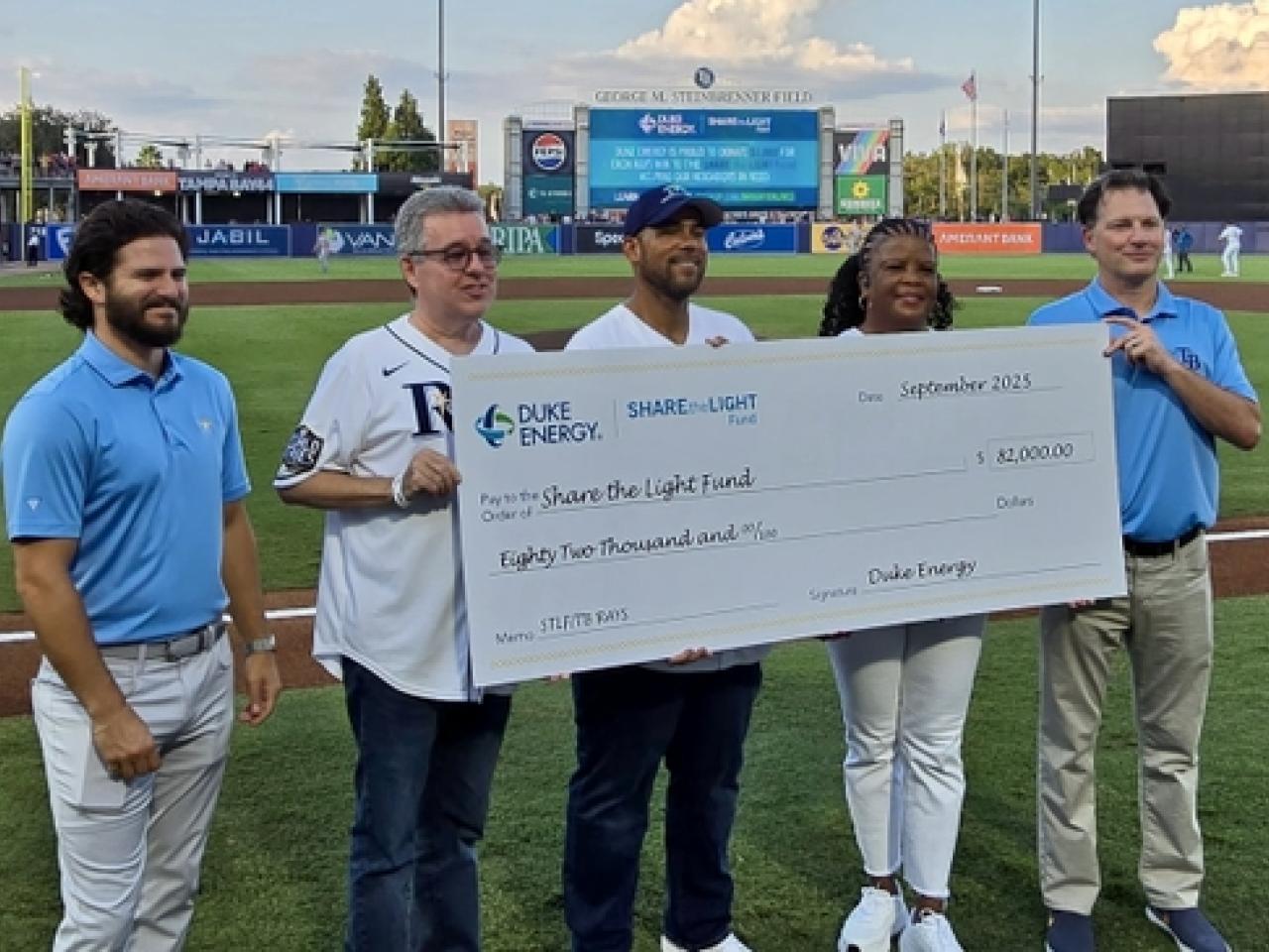 people holding up a large version of a check