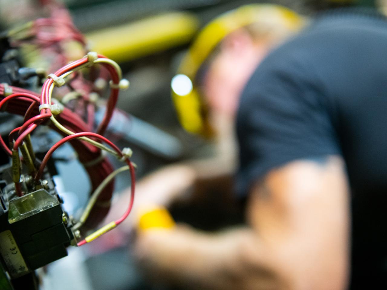 An electrician working, wires in the foreground
