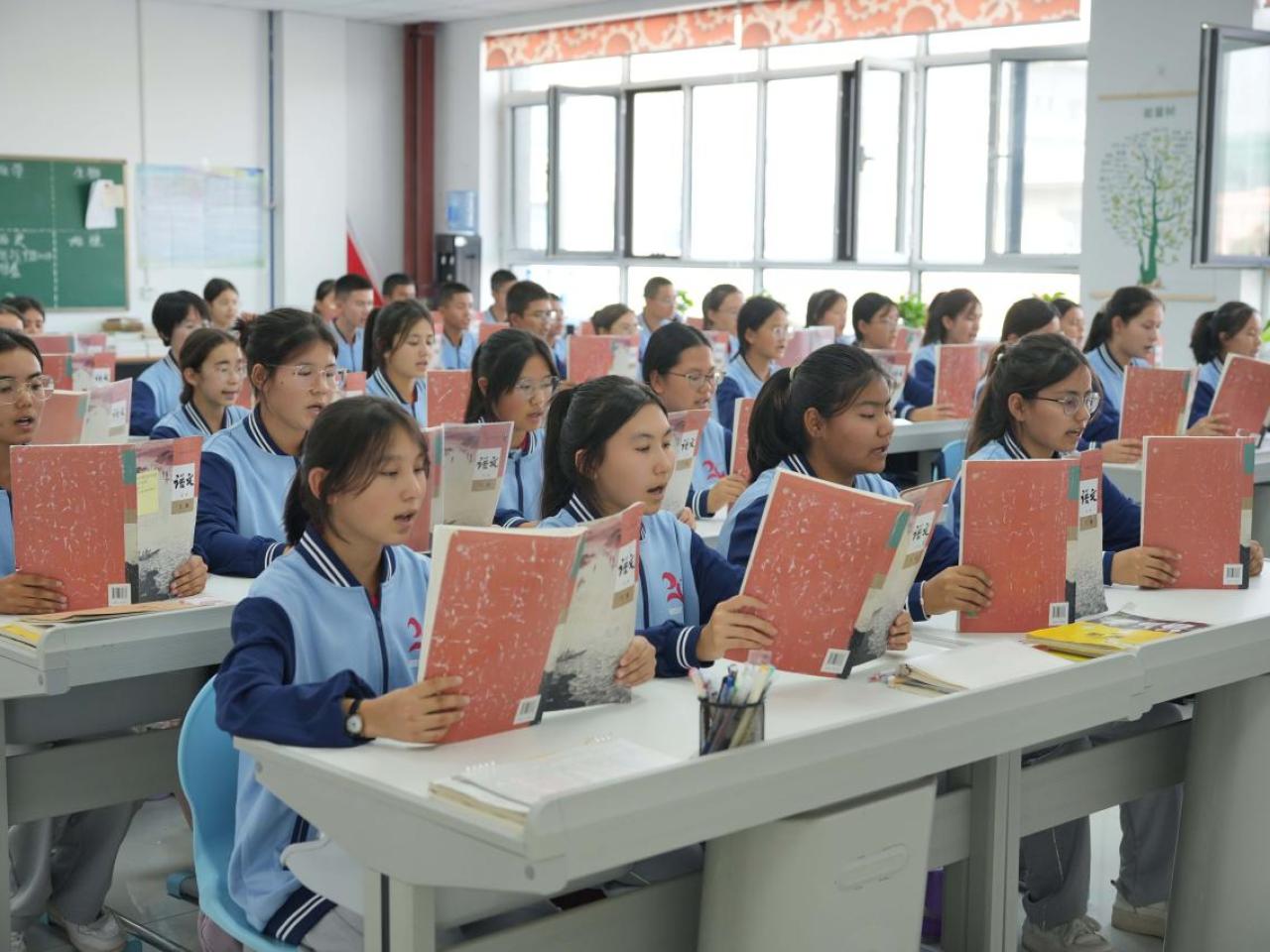 Students sitting in a classroom reading from books