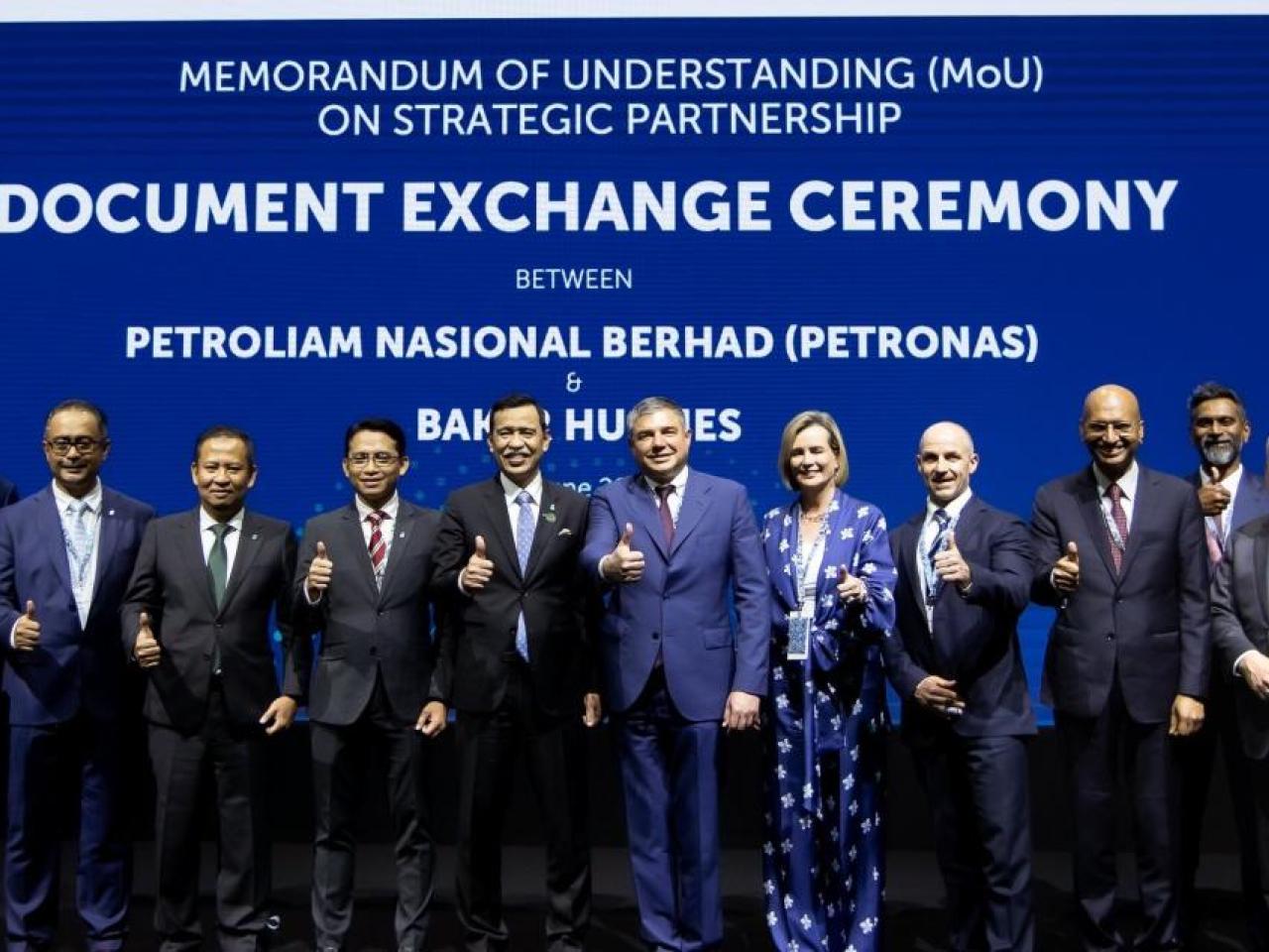 group photo at the Document Exchange Ceremony with participants giving the thumbs up sign