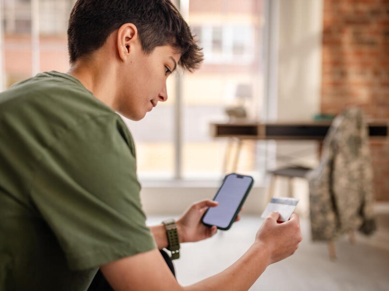 person looking at a card and their phone