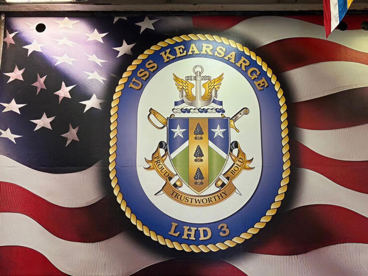 American flag with emblem for USS Kearsarge on top