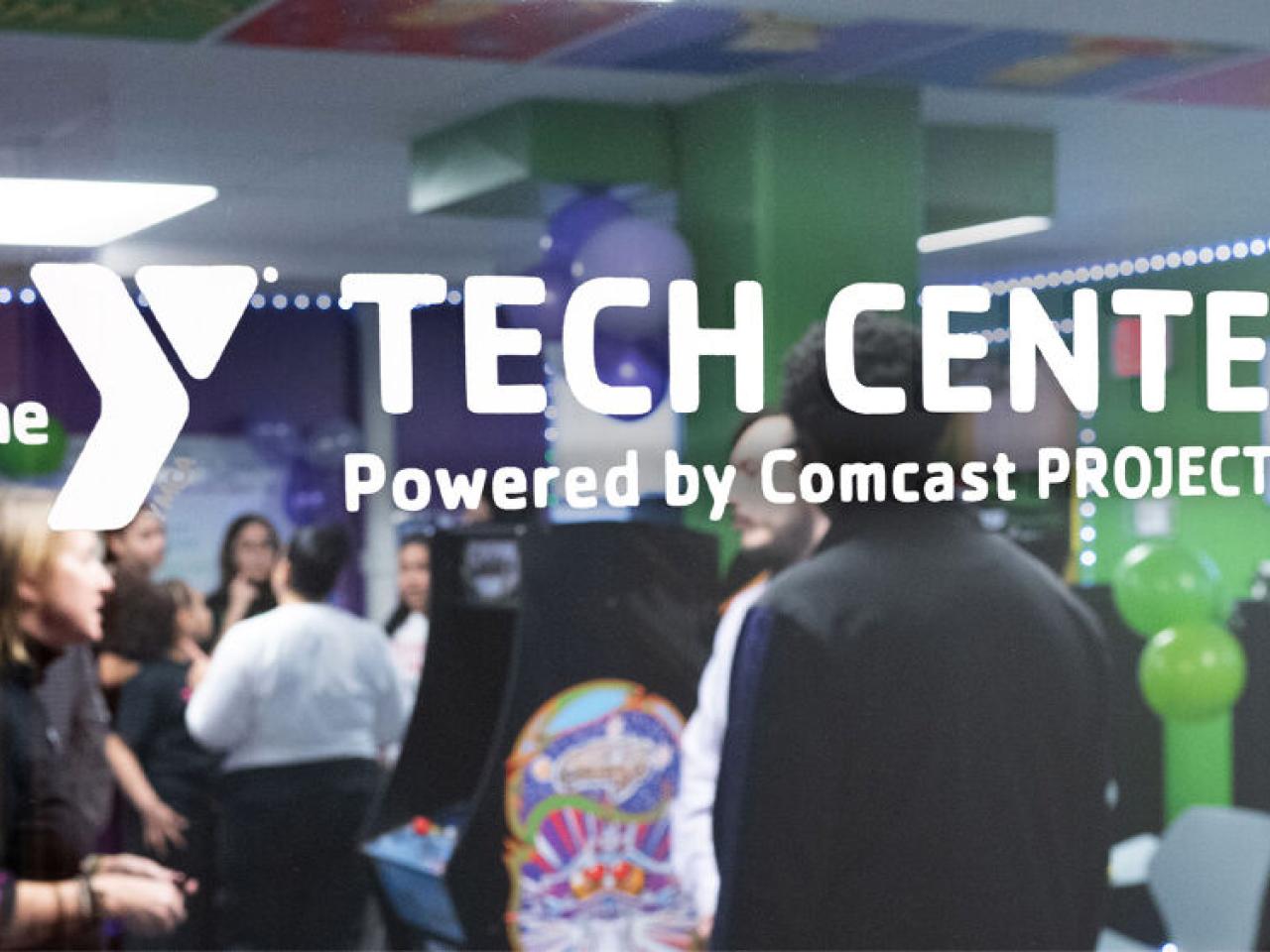 glass door with "the Y Tech Center Powered by Comcast PROJECT UP"