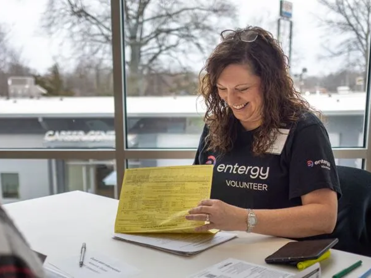 An Entergy volunteer smiling while helping a customer