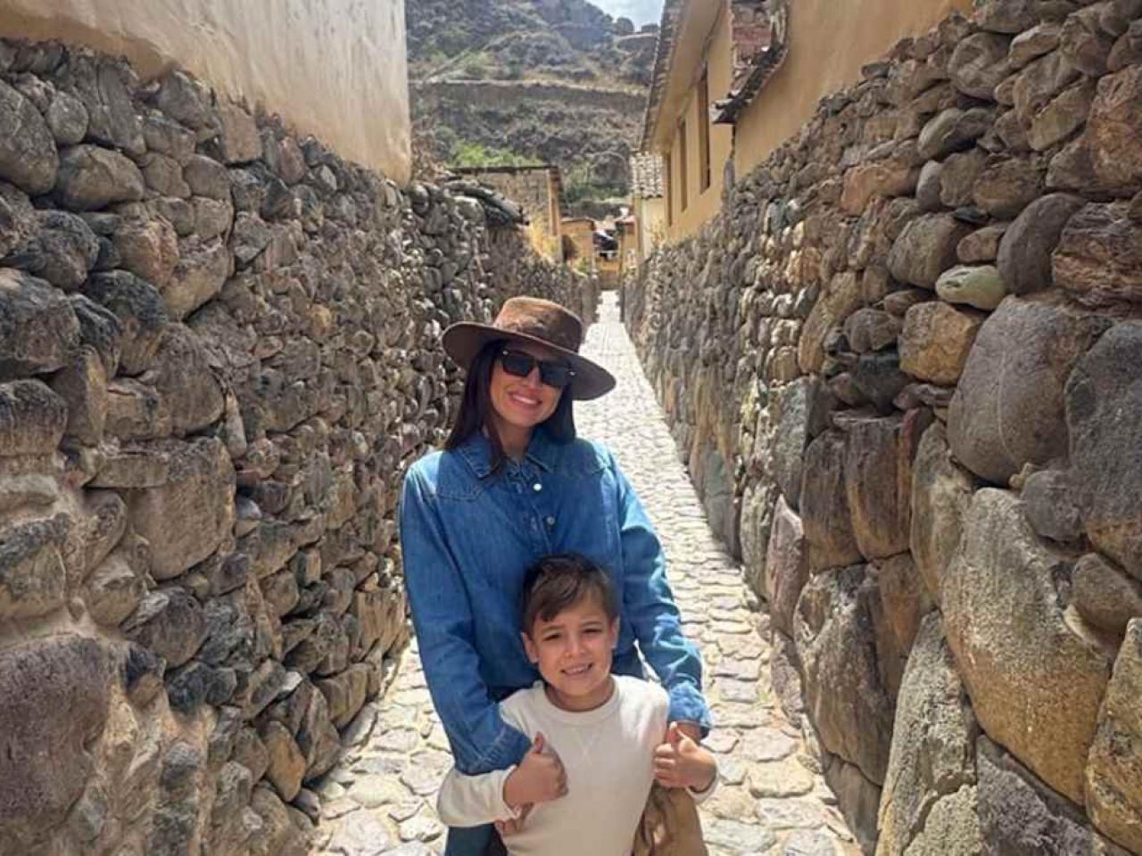 An adult and child standing together on a narrow cobblestone street