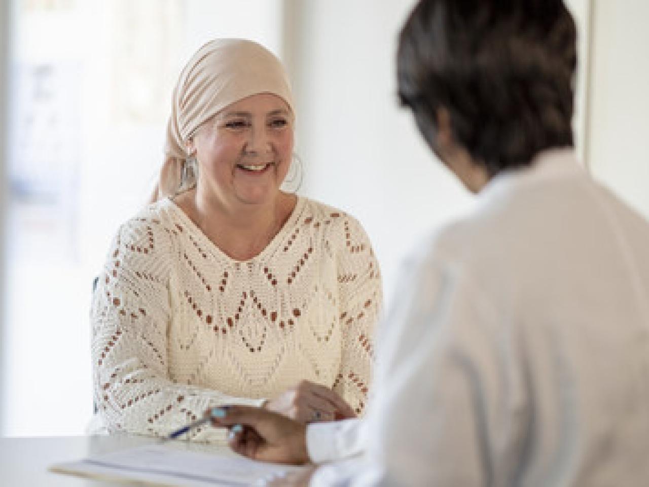 Female cancer patient consulting with a doctor. Patient is wearing a headscarf.