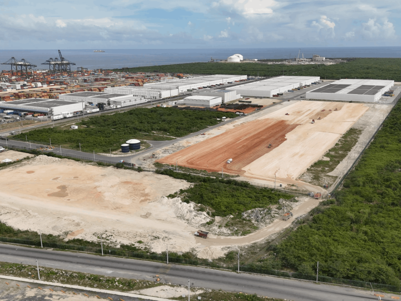 Aerial view of the Port of Caucedo and existing economic zone in the background, with cleared land in the foreground marking the site of DP World’s planned expansion.