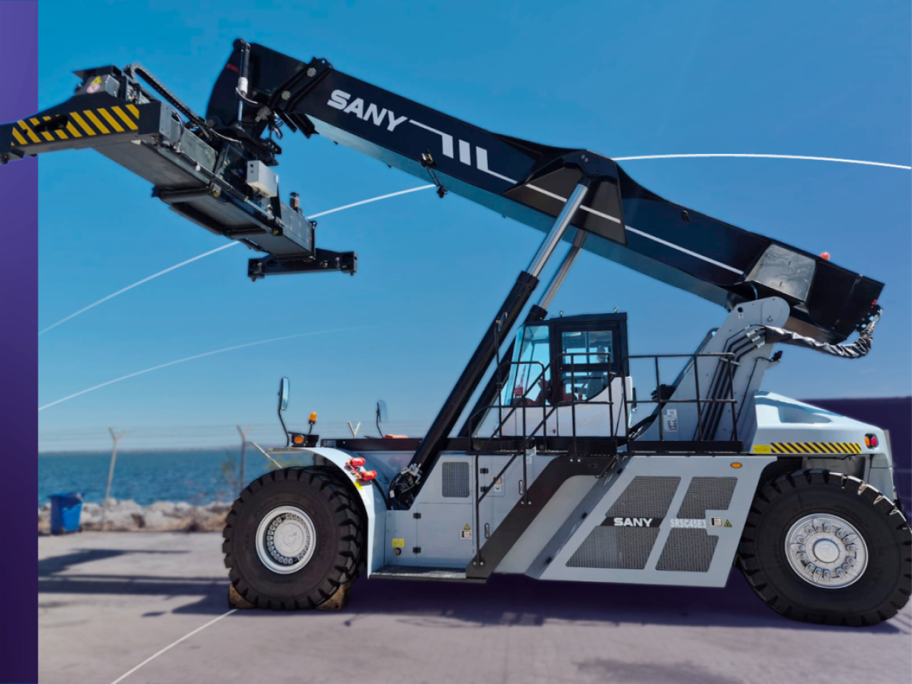 Side view of a fully electric SANY SRSC45E3 Reach Stacker at DP World’s Lirquén port terminal with ocean in background.