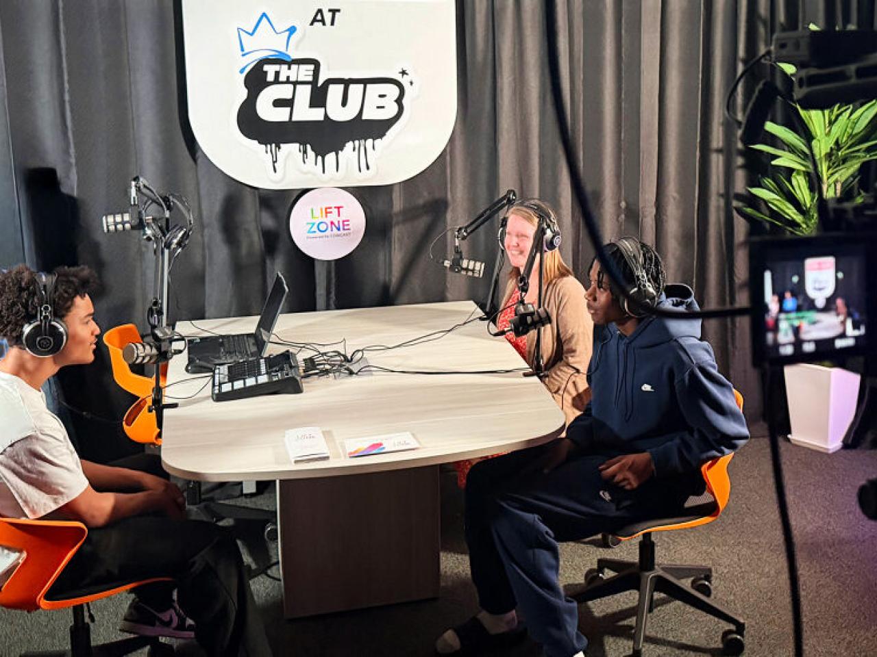 Three people talking with microphones and recording equipment