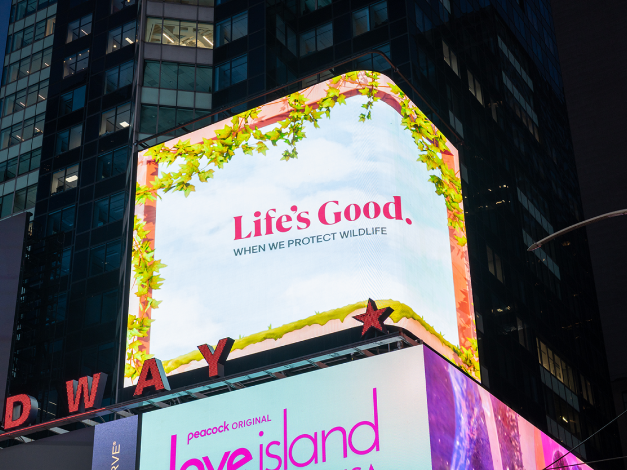 Lit billboard: "Life's Good when we protect wildlife"