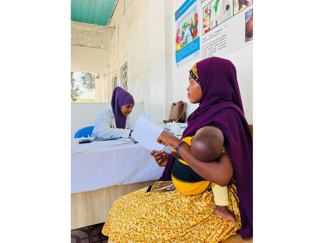At an Action Against Hunger-supported clinic in Kismayo, a mother is informed about the importance of vaccines for malnutrition prevention. 