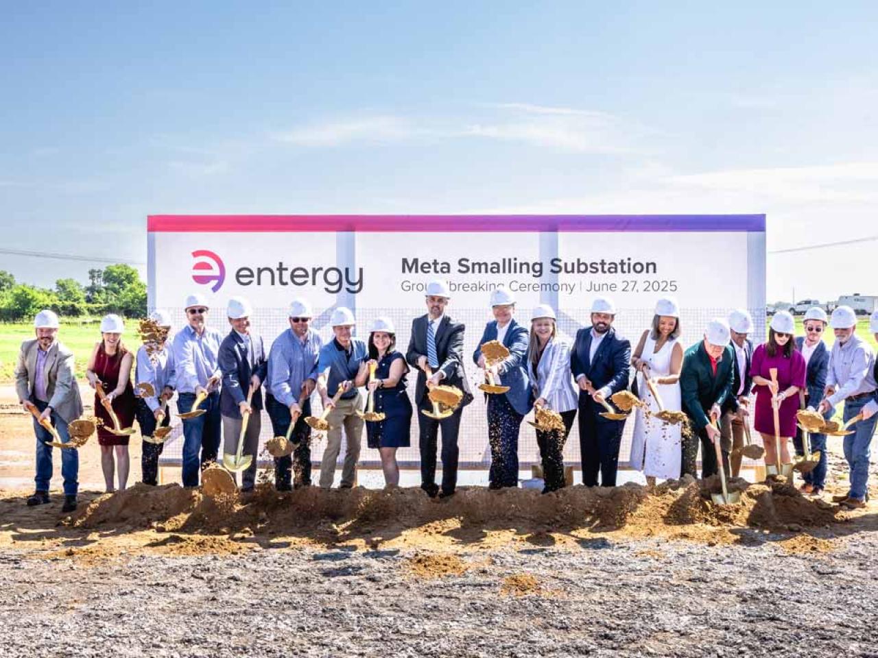 Group of people in hard hats with ceremonial shovels of dirt