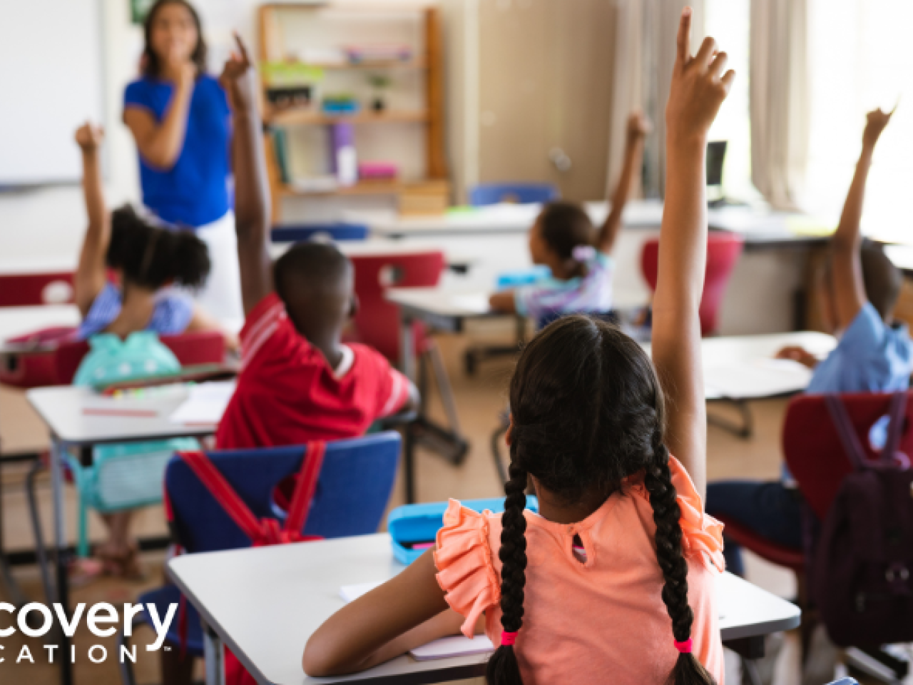 Children raising their hands in a classroom