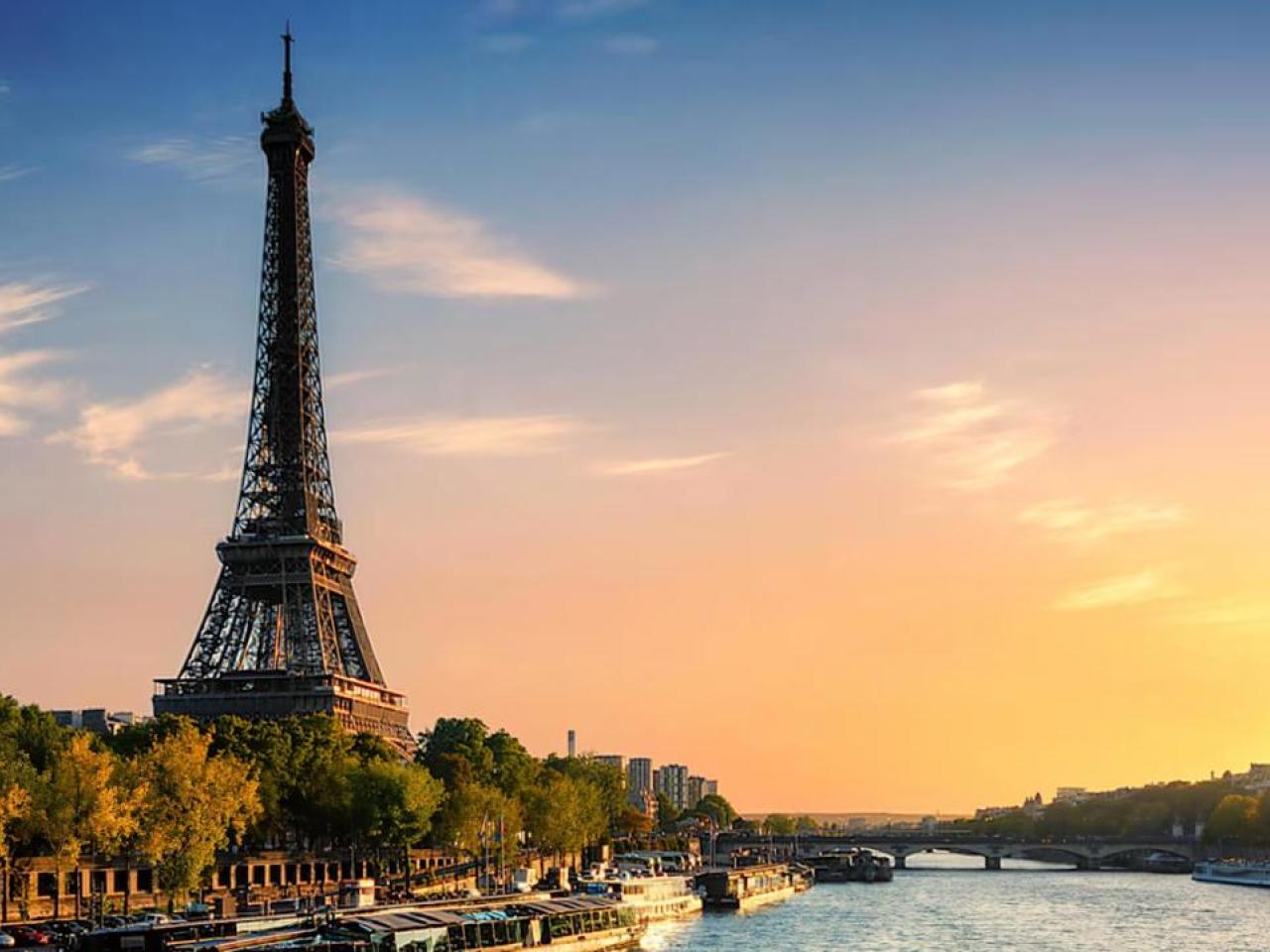 Eiffel Tower with a setting sun to the side.