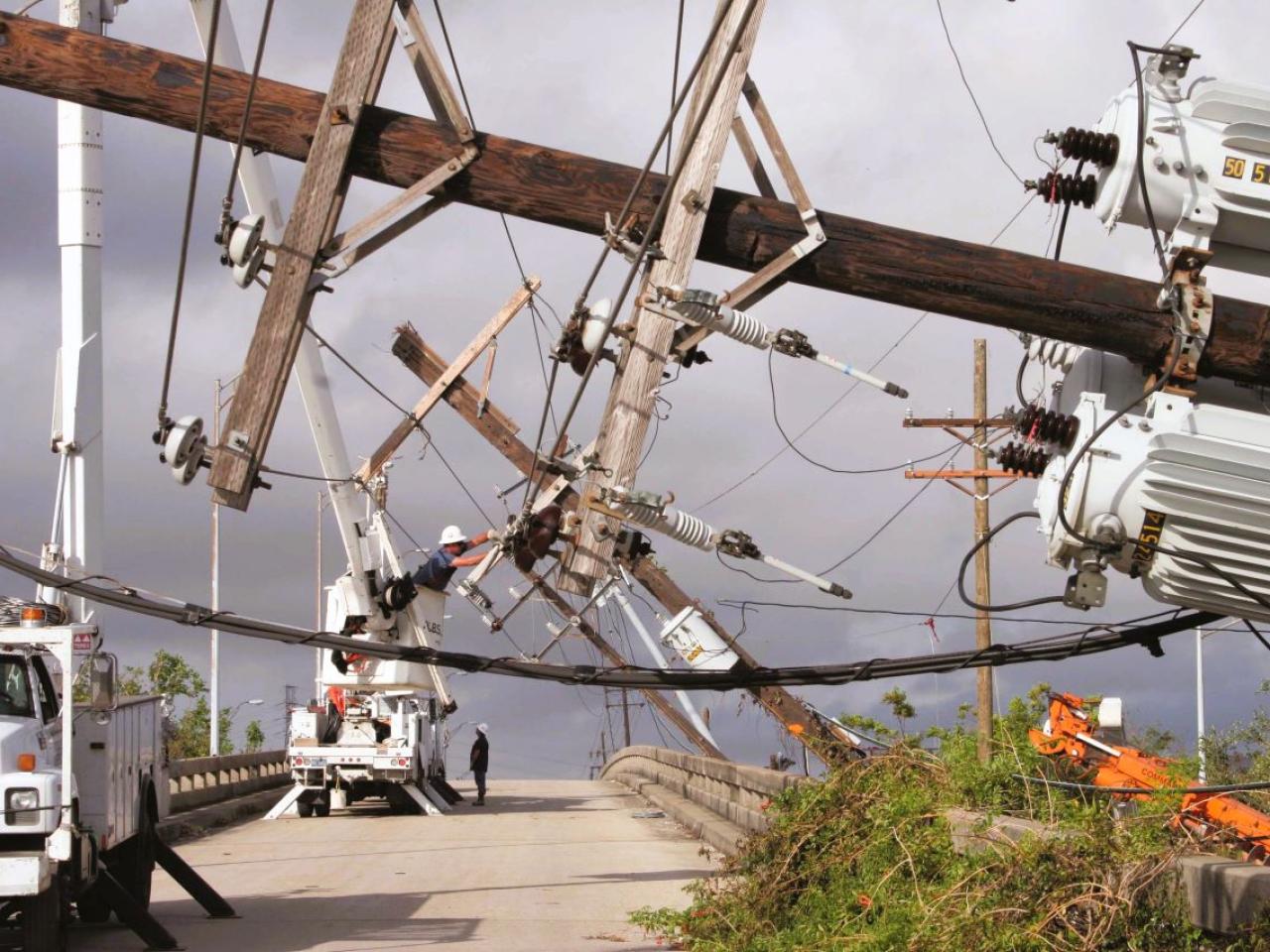 Downed power poles, with Entergy vehicles at work