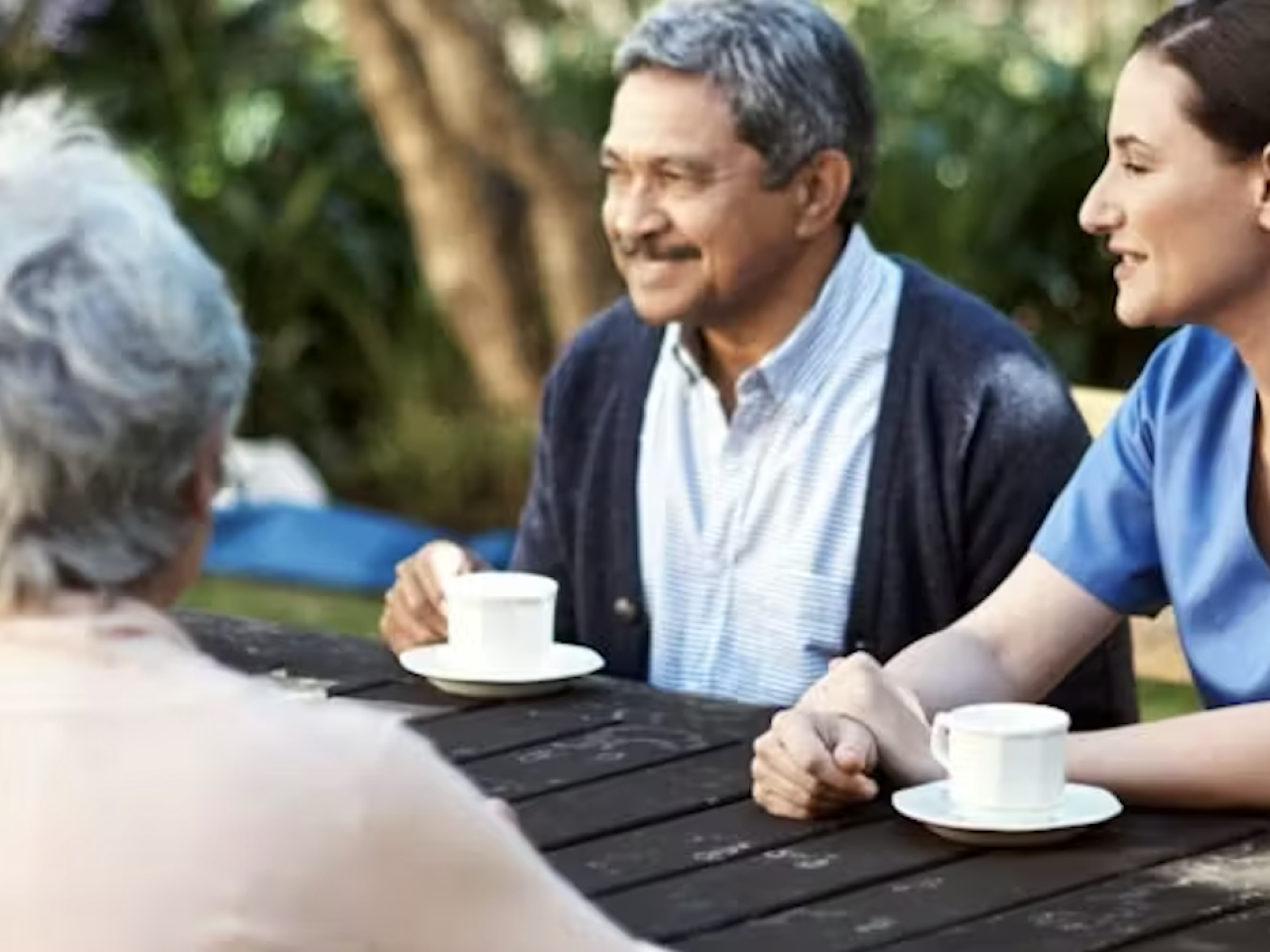 Three people drinking tea or coffee together