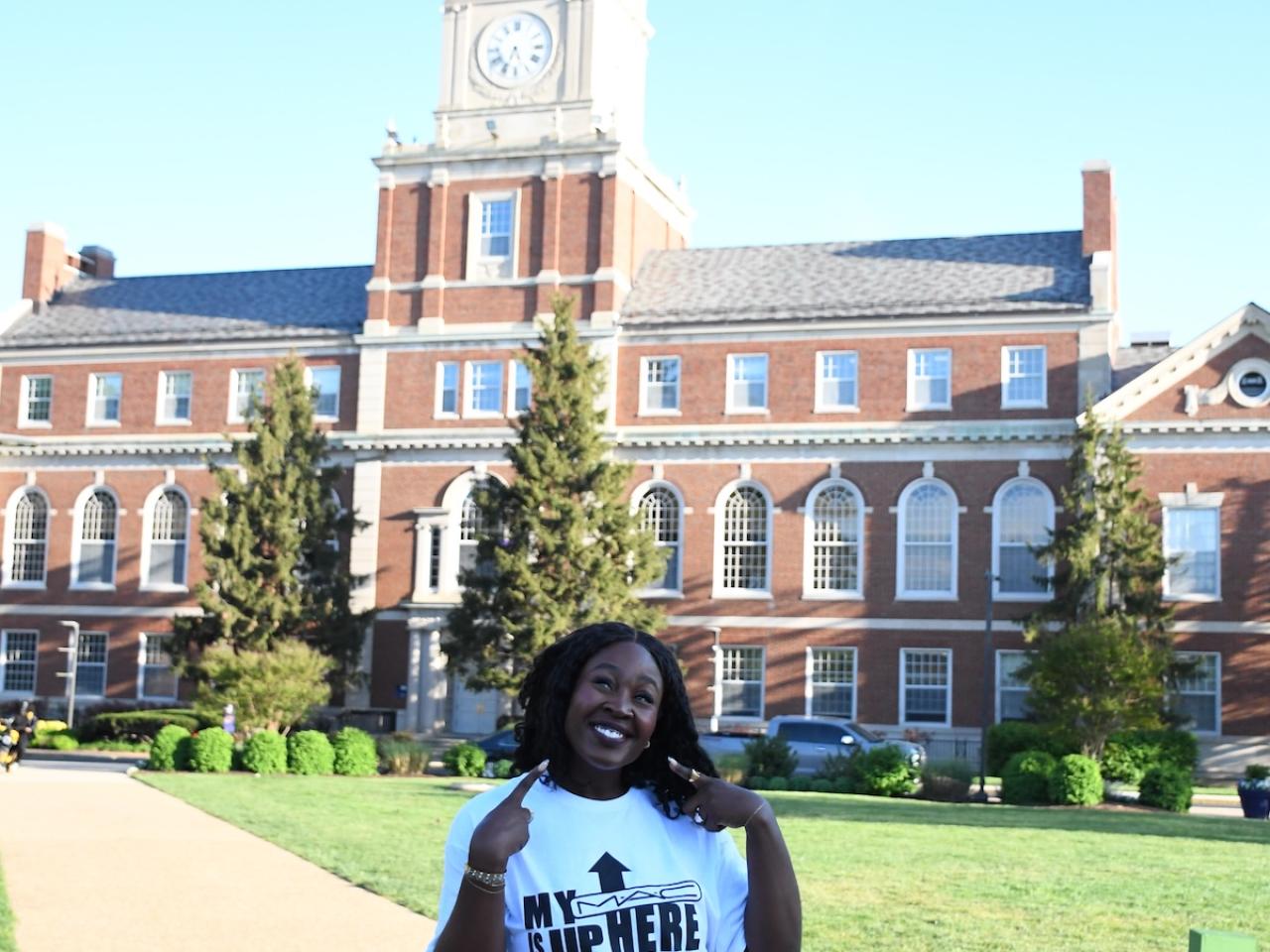 person smiling in front of brick building