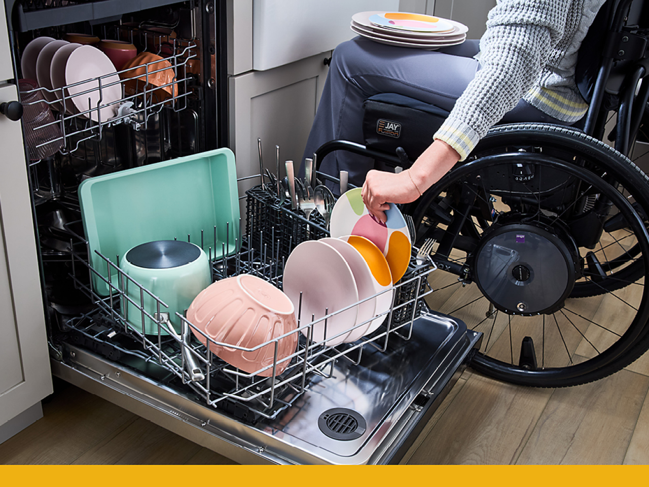 A person in a wheelchair unloading a dishwasher