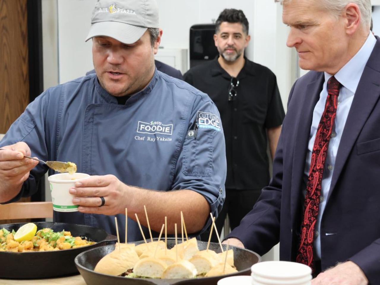 Someone dishing out food as the Senator looks on
