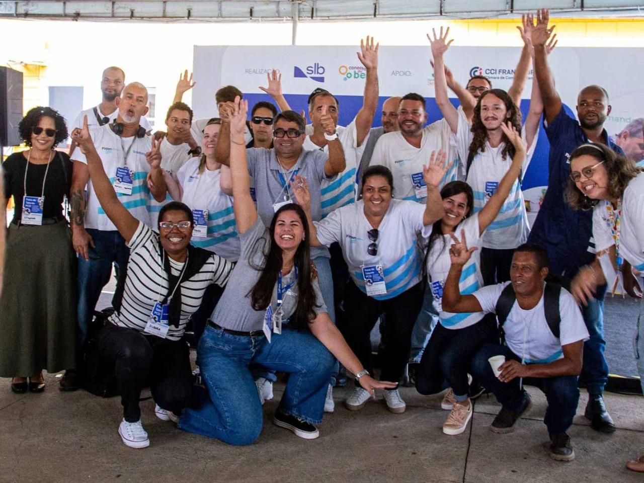 A group of people smiling and raising their arms