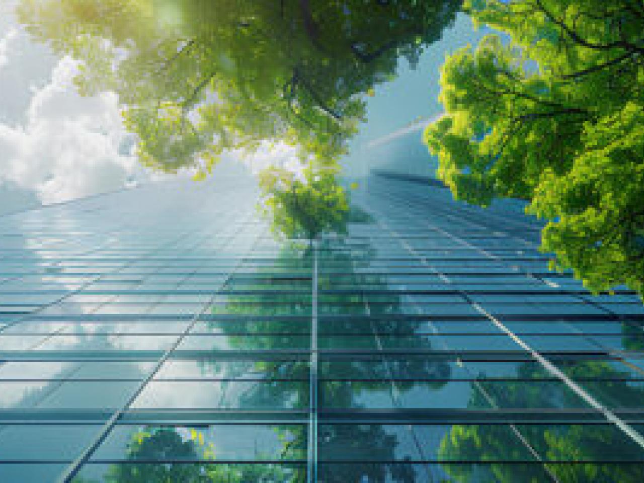ground view of a glass building with trees and clouds