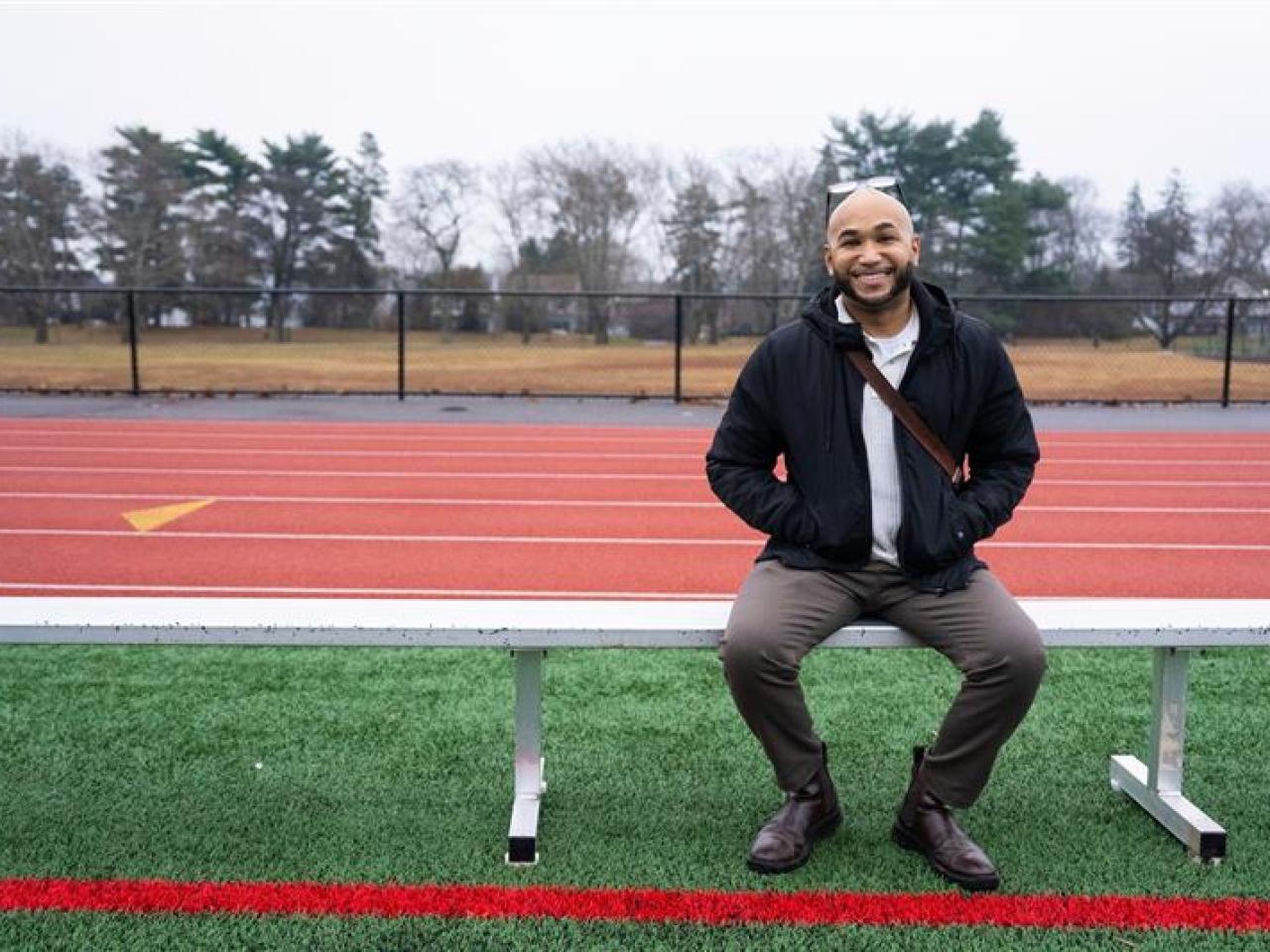 person sitting on a bench at a track