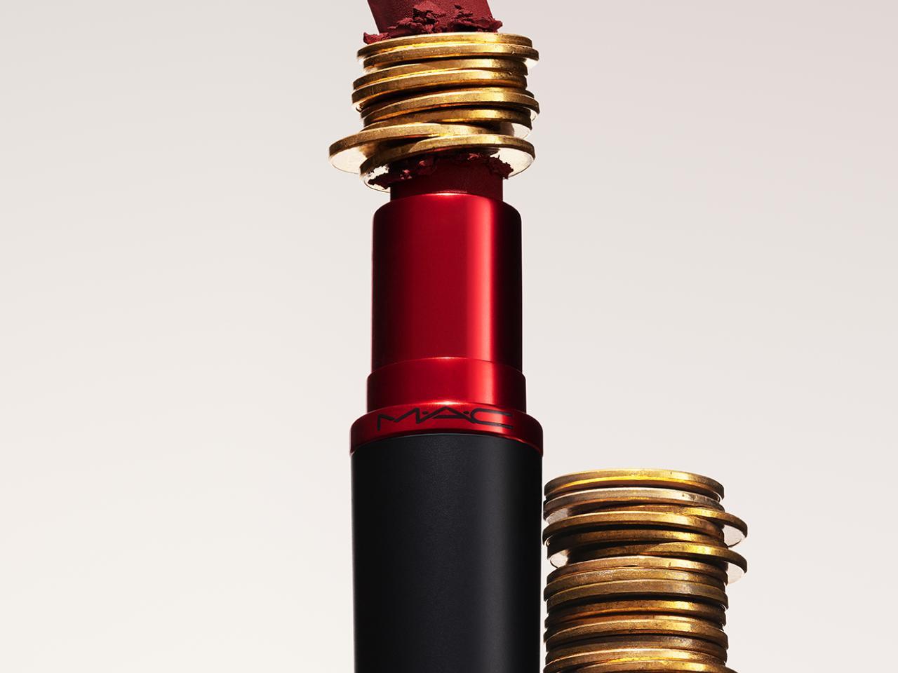 A lipstick with stacked coins in the middle of it and to the side.
