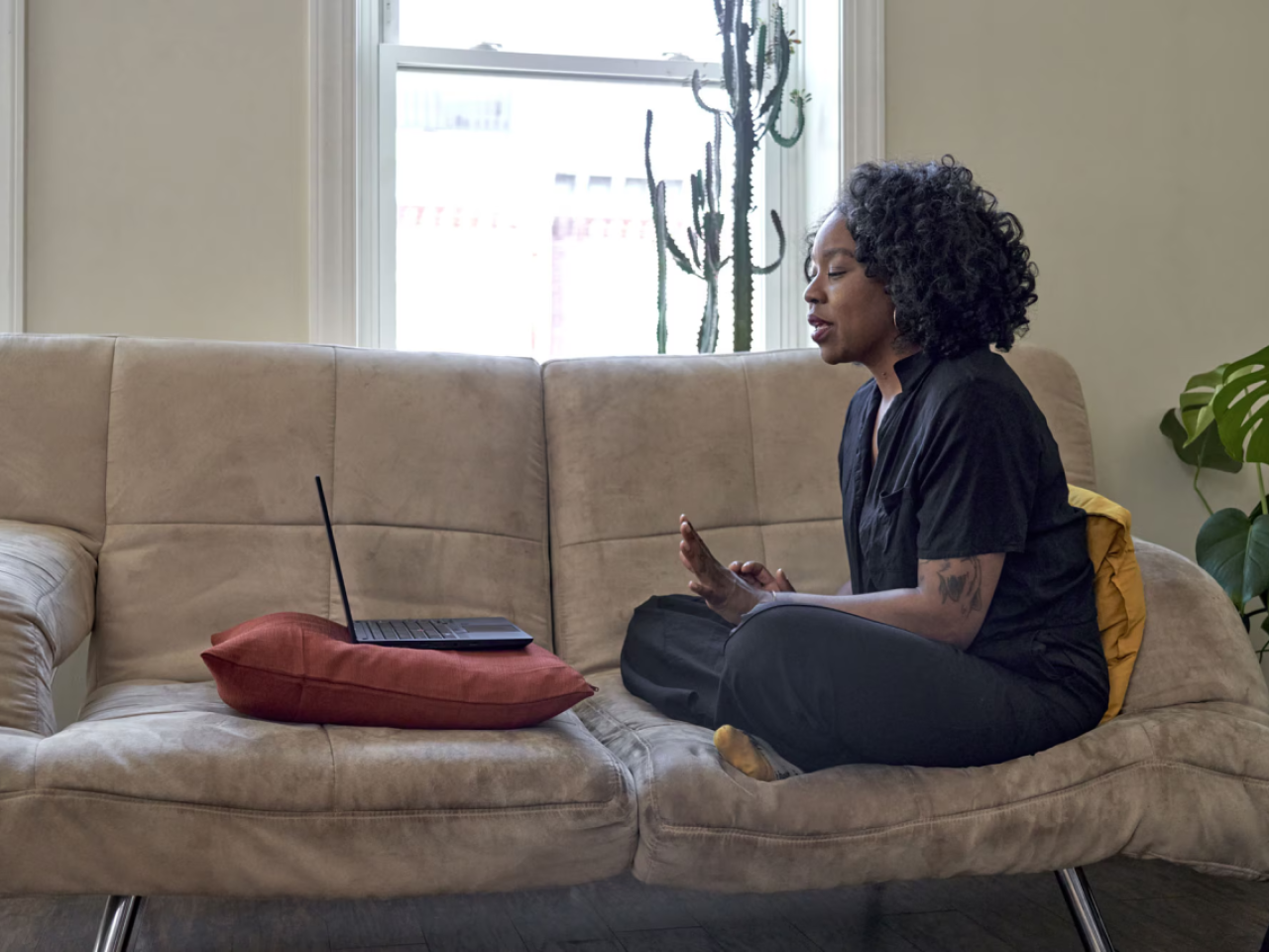 A woman sitting on a couch, in an online meeting