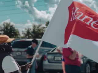 Woman holding a HanesBrands flag.