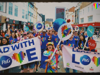 Pride parade with signs "Lead with Love" P&G