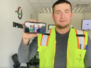 Man holding a phone with picture of his family on it