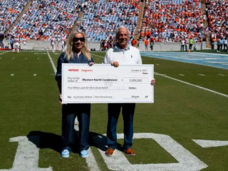 Two people holding an oversized check