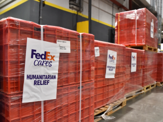 Humanitarian Relief in red crates with a sign that reads "FedEx Cares" 