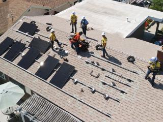Birdseye view of Edison volunteers installing solar panels on a roof