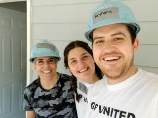 Anthony Reyna & wife at GP Build with Erin Beckman in front of a house.