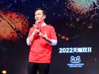 Cheng Li with a microphone, a large screen behind them with "2022" and other writing in a foreign language.