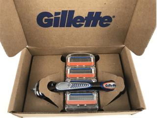 An open cardboard box with Gillette logo on the inside. A razor handle and cartridge refills packaged inside.